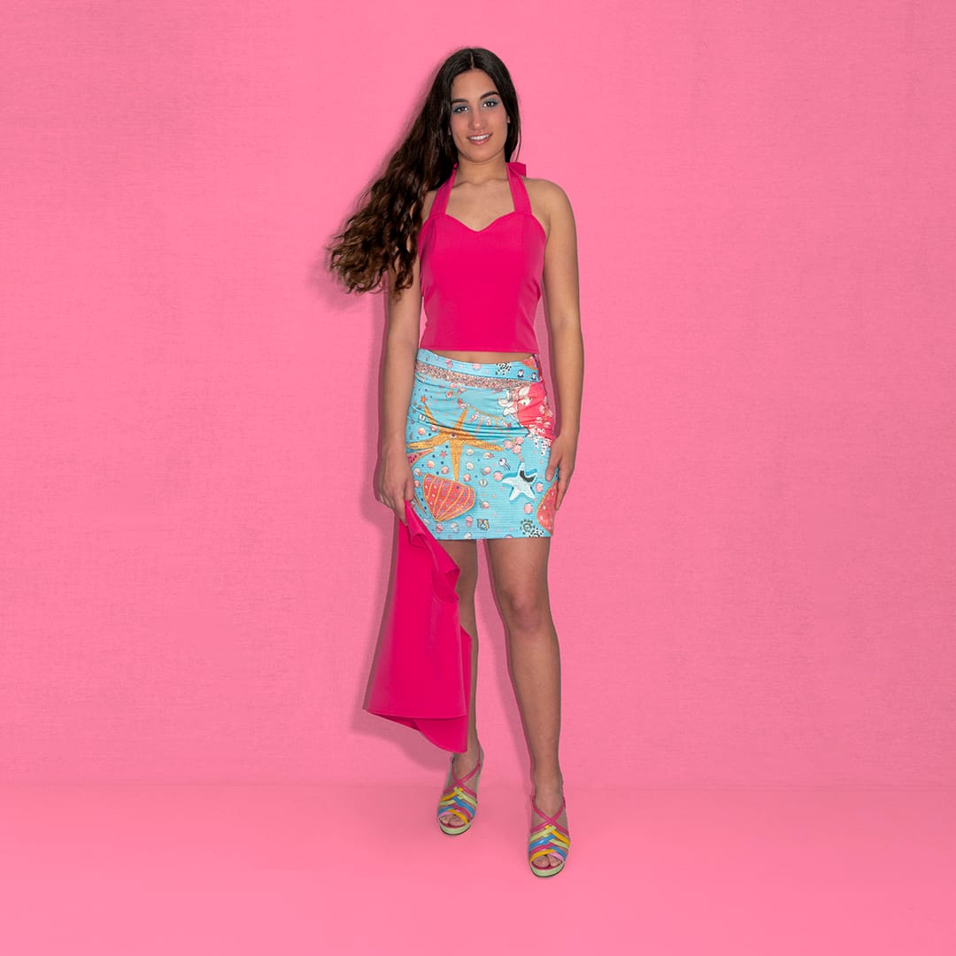 Corpiño fucsia atado al cuello con falda midi estampado de estrellas marinas diseñado por Matilda en azul turquesa y fuscia